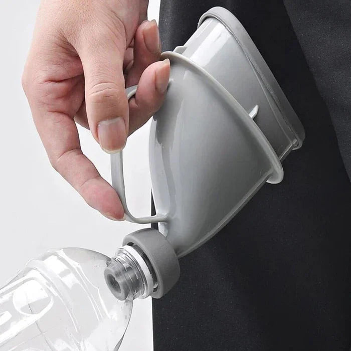 Portable Travel Urinal - Hand holding gray travel urinal connected to a clear plastic bottle near dark fabric