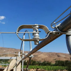 A metal wire tensioner installed on a farm support pipe with taut wire attached