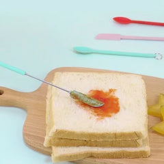Mini Silicone Telescopic Spatula - Small silicone-tipped tool spreads sauce onto a slice of white bread on a wooden cutting board.