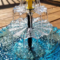 Hanging Bird Bath - Close-up of a three-tier fountain's two clear cascading tiers, yellow nozzle, and blue basin over wood decking