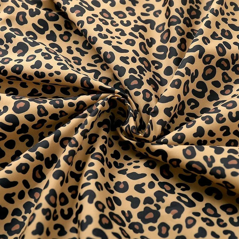 Hooded Jacket - Close-up of twisted leopard print fabric with a beige base, black spots and tan spot centers, gathered into a central fold