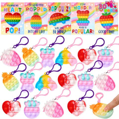 Assorted pop fidget keychains (pineapple, bear, heart, car shapes) and matching greeting cards; valentines day cards with pop fidget keychains are shown.