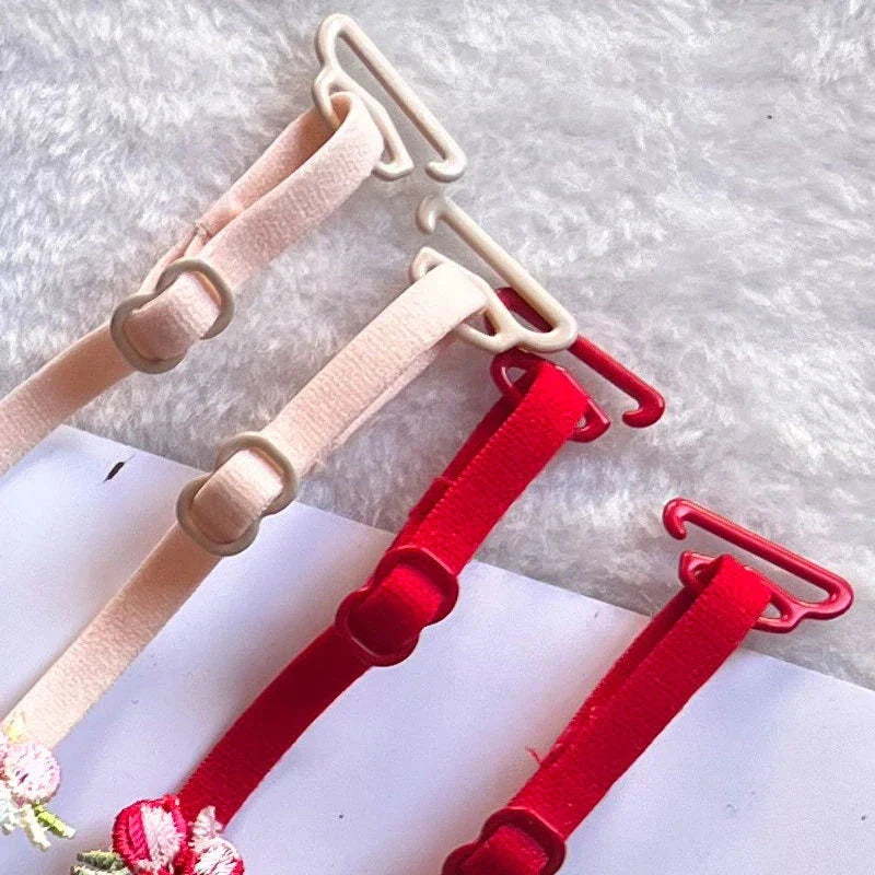 Bra Straps - Close-up of elastic bra strap adjusters and hooks in light beige and red tones.