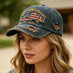 Gorra de béisbol conmemorativa: gorra de béisbol del 250 aniversario estilo mezclilla azul oscuro desgastada, usada por una mujer con cabello rubio ondulado, fondo al aire libre