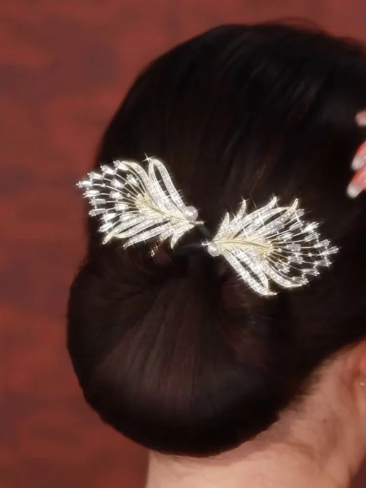 Pfauenfeder Haarschmuck - Glänzender Kristall- und Perlen-Pfauenfeder-Haarschmuck in einem dunklen tiefen Dutt getragen