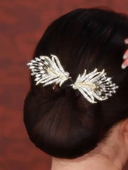 Pfauenfeder Haarschmuck - Glänzender Kristall- und Perlen-Pfauenfeder-Haarschmuck in einem dunklen tiefen Dutt getragen