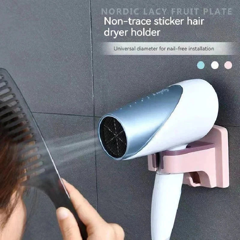 haartrockner ständer - Eine Person kämmt sich die Haare, während ein Haartrockner in einem rosa Badezimmer-Haartrocknerhalter sitzt, der an einer dunkelgrau gefliesten Wand montiert ist.