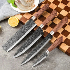 Hammered Knife Set - Four kitchen knives with hammered dark blades and wood-grain handles, placed by a checkered cutting board with shrimp, lemon, and a grey cloth