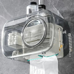 Cotton Pad Dispenser Holder - Clear wall mount tissue box, showing stacked tissues inside, with an outgoing tissue at the bottom and hanging decorations on the side.
