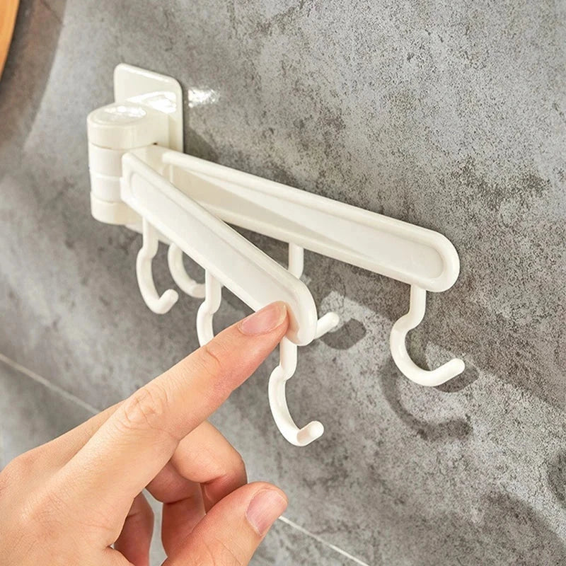 Adhesive Wall Hooks - Hand adjusting the position of a rotating arm on the wall-mounted hook rack, mounted on a gray textured tile surface