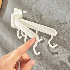 Adhesive Wall Hooks - Hand adjusting the position of a rotating arm on the wall-mounted hook rack, mounted on a gray textured tile surface