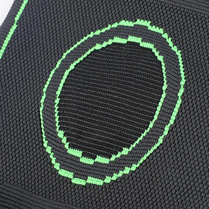 Compression Sleeve - Close-up of black knit fabric with bright green stitched oval ring patterns