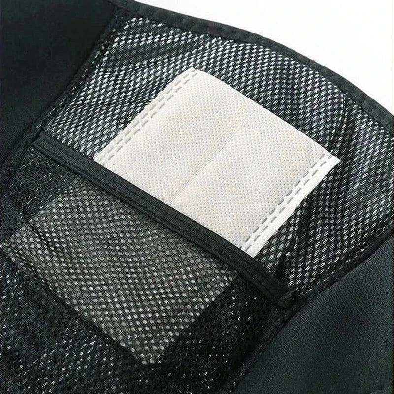 Knee Massager With Heat - Close-up of a white fabric insert in the mesh pocket of a black brace