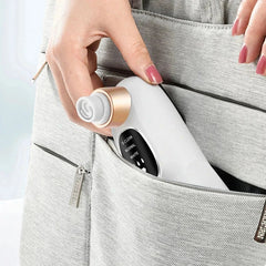 Beauty Device - A hand places a white oral irrigator with a rose gold accent into a light gray fabric bag pocket.