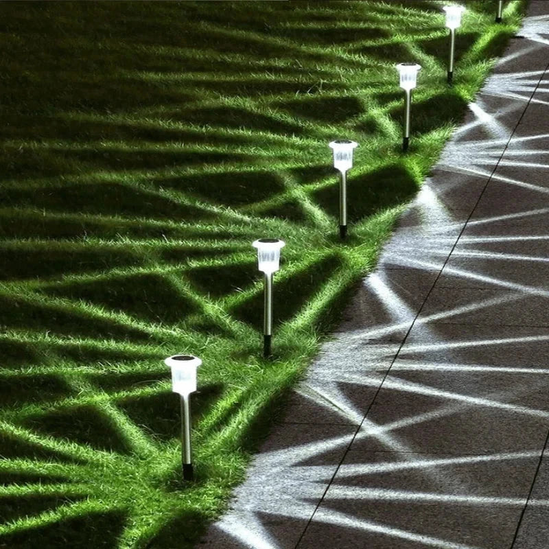Solar powered garden lights illuminating a garden path at dusk
