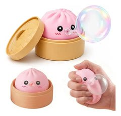 Sensory Bubble - Pink cartoon steamed bun squeeze toy with bamboo steamer container, shown blowing a bubble and being squeezed in hand.