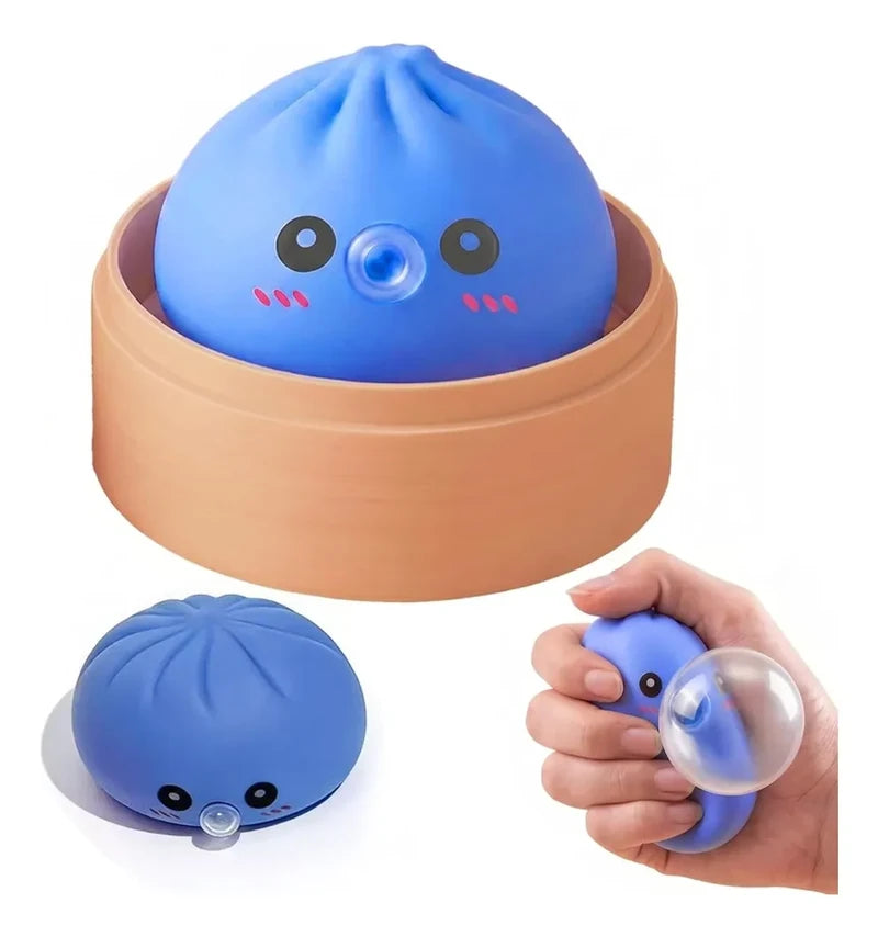 Sensory Bubble - A blue cartoon-faced steamed bun toy in a light brown steamer, shown uncompressed and squeezed to blow a clear bubble.