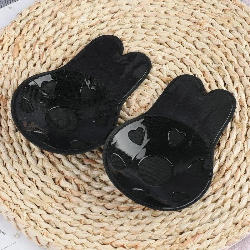 Nipple Concealers - Close-up of a pair of black rabbit-ear shaped nipple covers, showing the adhesive inner side with heart-shaped cutouts