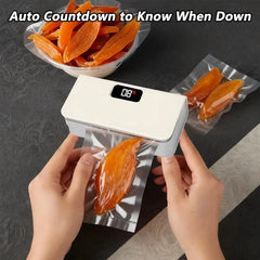 Mini Bag Sealer - Hands holding the sealer to seal a bag with dried fruit, digital display shows countdown during operation
