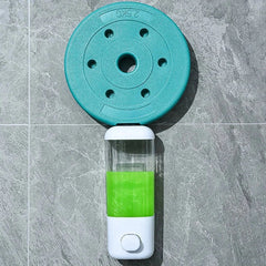 Wall-mounted travel set bottles dispenser below a teal 2.5KG weight plate, attached to grey tiled surface