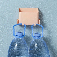 Caja de almacenamiento de pared - Contenedor de plástico color melocotón montado en la pared sobre una superficie azul claro con gotas de agua, con dos botellas grandes de agua colgando de sus ganchos frontales
