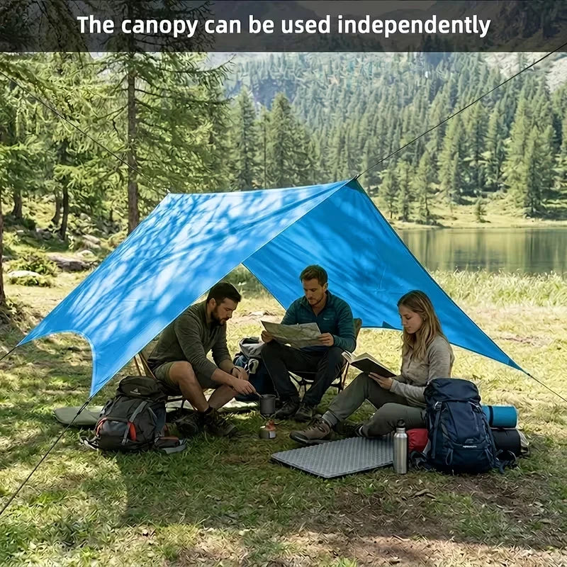 Mosquitero - Tres personas sentadas bajo un cobertizo de camping azul cerca de un lago rodeado de árboles, con equipo de camping dispuesto a su alrededor, texto superpuesto sobre el uso independiente del cobertizo.