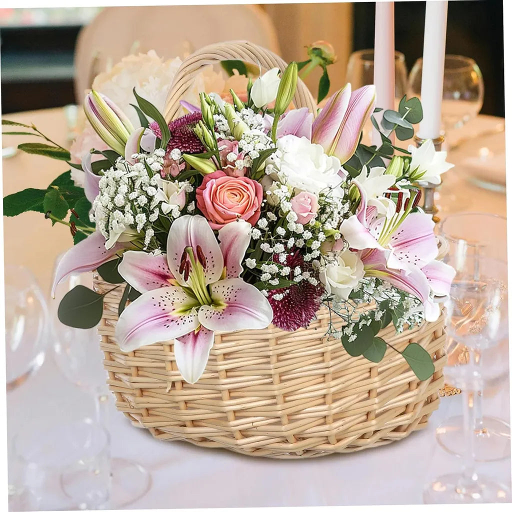 Elegant floral arrangement in woven basket with pink lilies, peach roses, and greenery at formal table setting