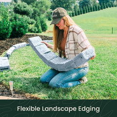 Woman installing flexible grey stone landscape edging in garden