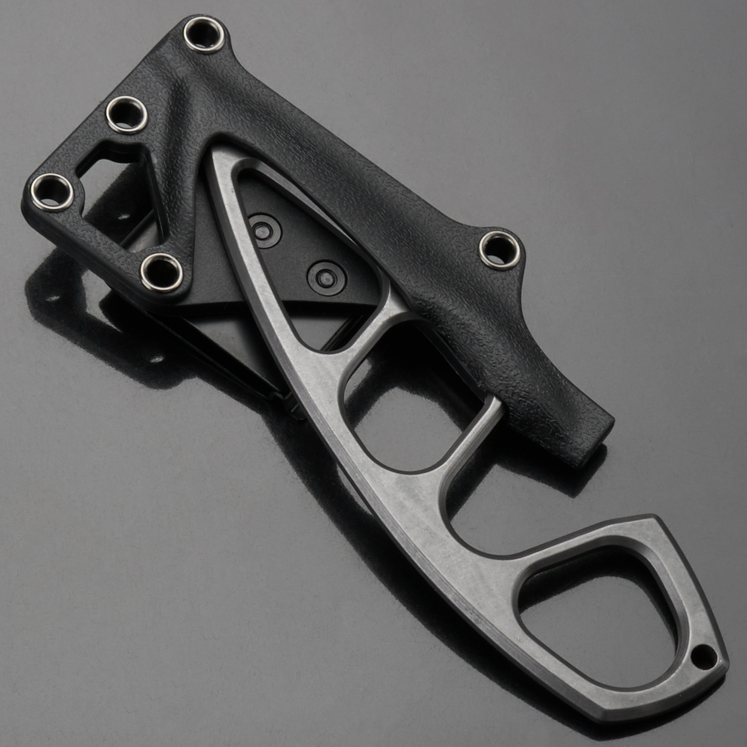 gs226 skeleton knife partially drawn from black textured Kydex sheath, set on dark glossy reflective surface