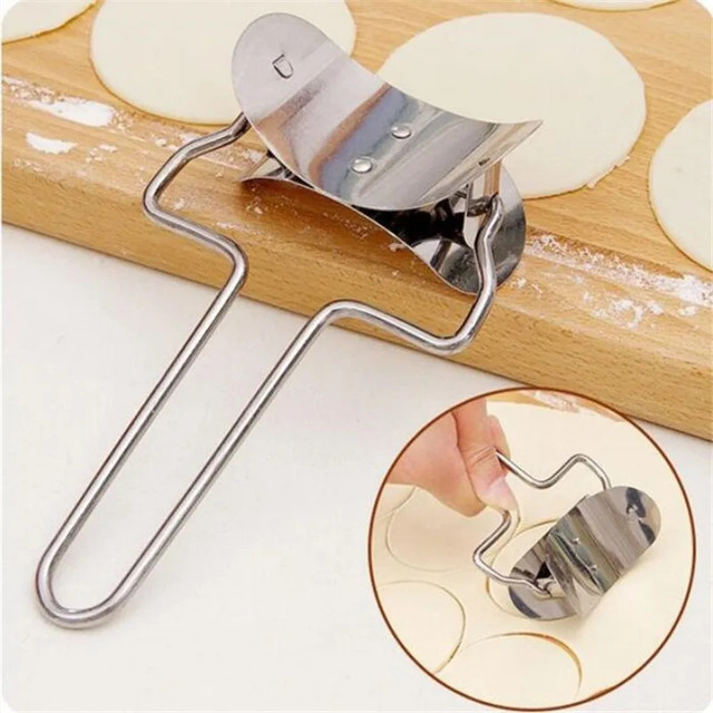 Stainless steel dumpling wrapper cutter on wooden pastry board