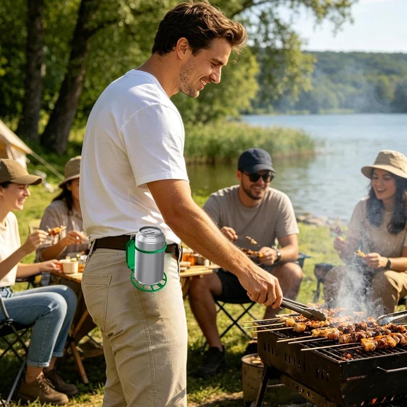 Man grilling at lakeside outdoor party with beer can holder clipped on his belt